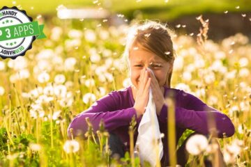 Pollenflug-Apps: Frau sitzt auf Wiese und muss sich die Nase putzen