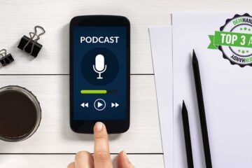 Podcast-App: Handy auf einem Tisch mit der Aufschrift Podcast im Bildschirm