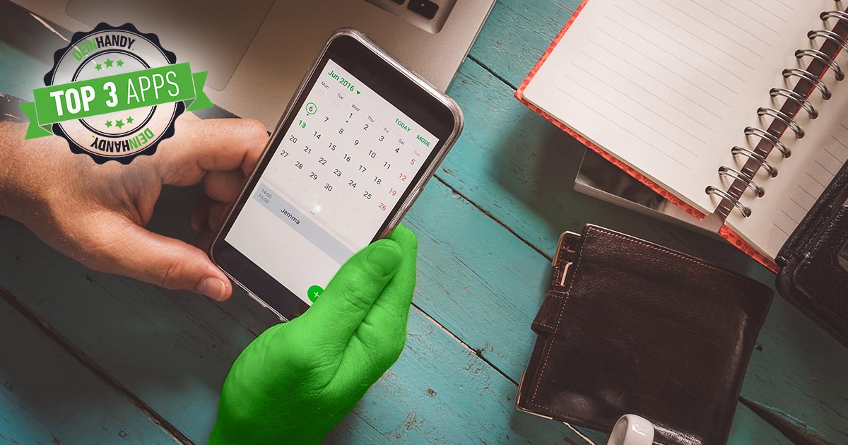 Kalender-App: Smartphone in der Hand, Tisch im Hintergrund