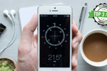 Kompass-App: Handy mit Kompass über einem Tisch mit Kaffeetasse